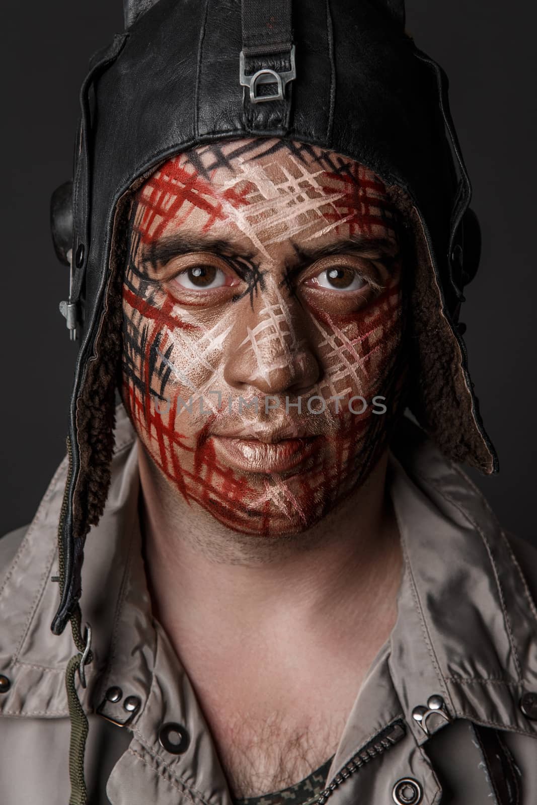 Portrait of Brutal Man with Creative Military Style Camouflage. Face Paint.  Close up on black background