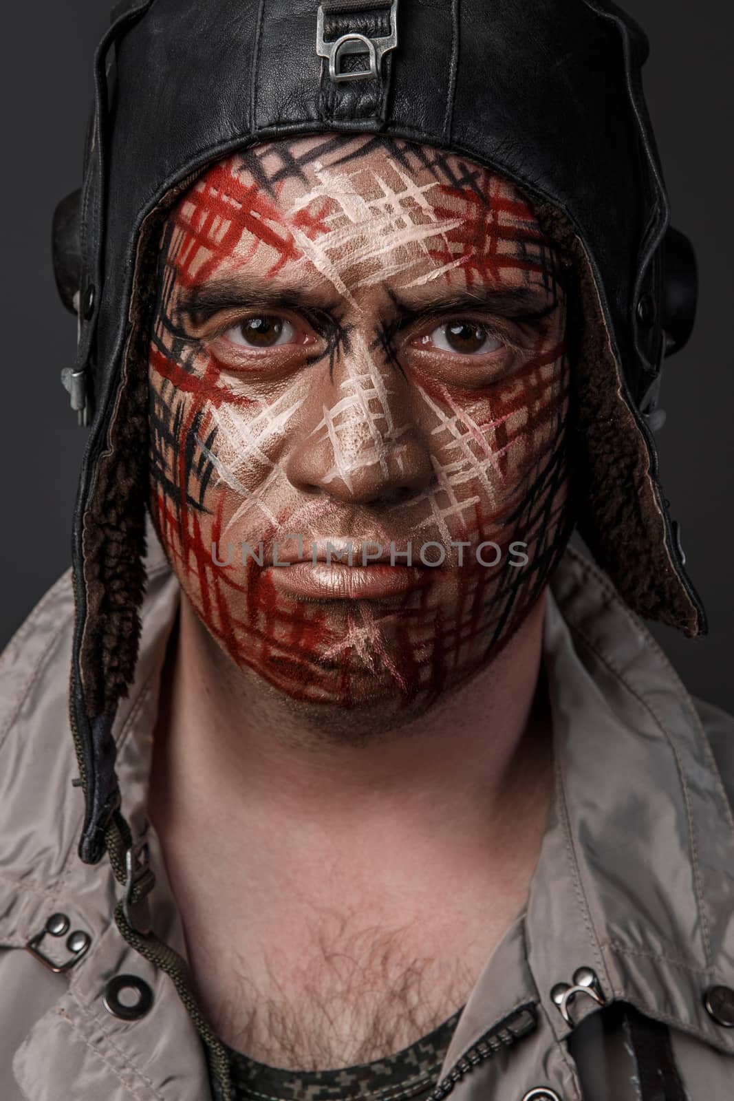 Portrait of Brutal Man with Creative Military Style Camouflage. Face Paint.  Close up on black background