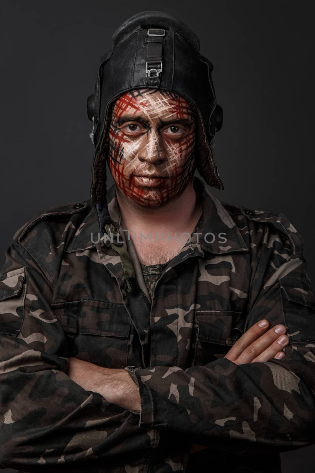 Portrait of Brutal Man with Creative Military Style Camouflage. Face Paint.  Close up on black background