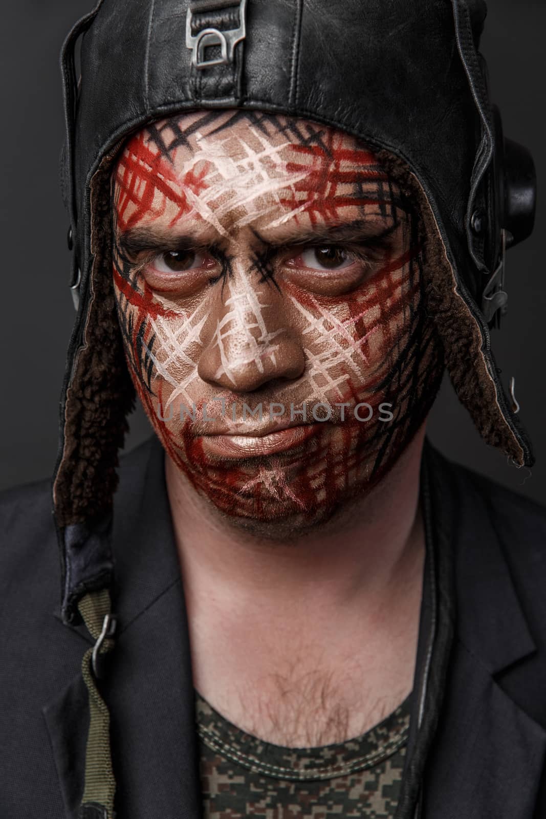 Portrait of Brutal Man with Creative Military Style Camouflage. Face Paint.  Close up on black background