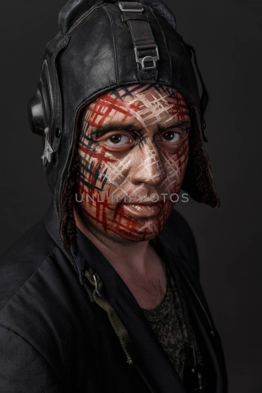 Portrait of Brutal Man with Creative Military Style Camouflage. Face Paint.  Close up on black background