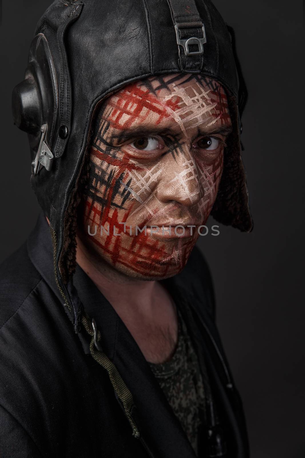 Portrait of Brutal Man with Creative Military Style Camouflage. Face Paint.  Close up on black background