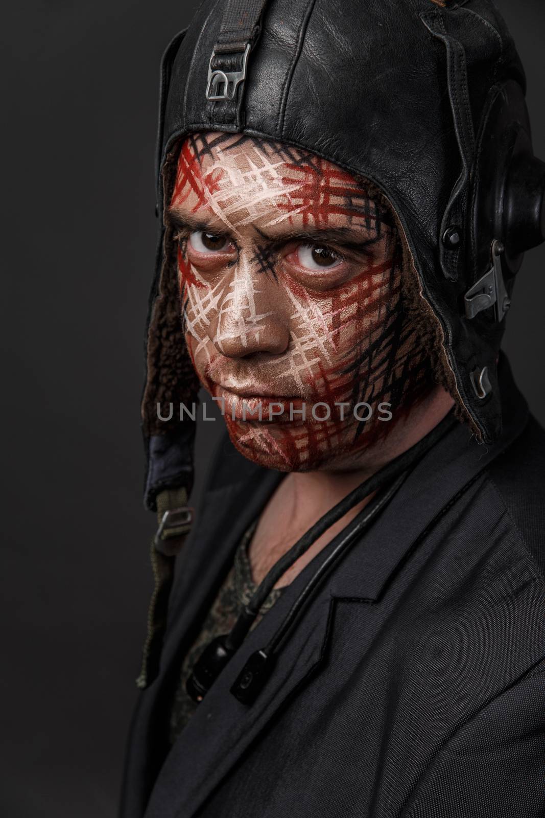 Portrait of Brutal Man with Creative Military Style Camouflage. Face Paint.  Close up on black background