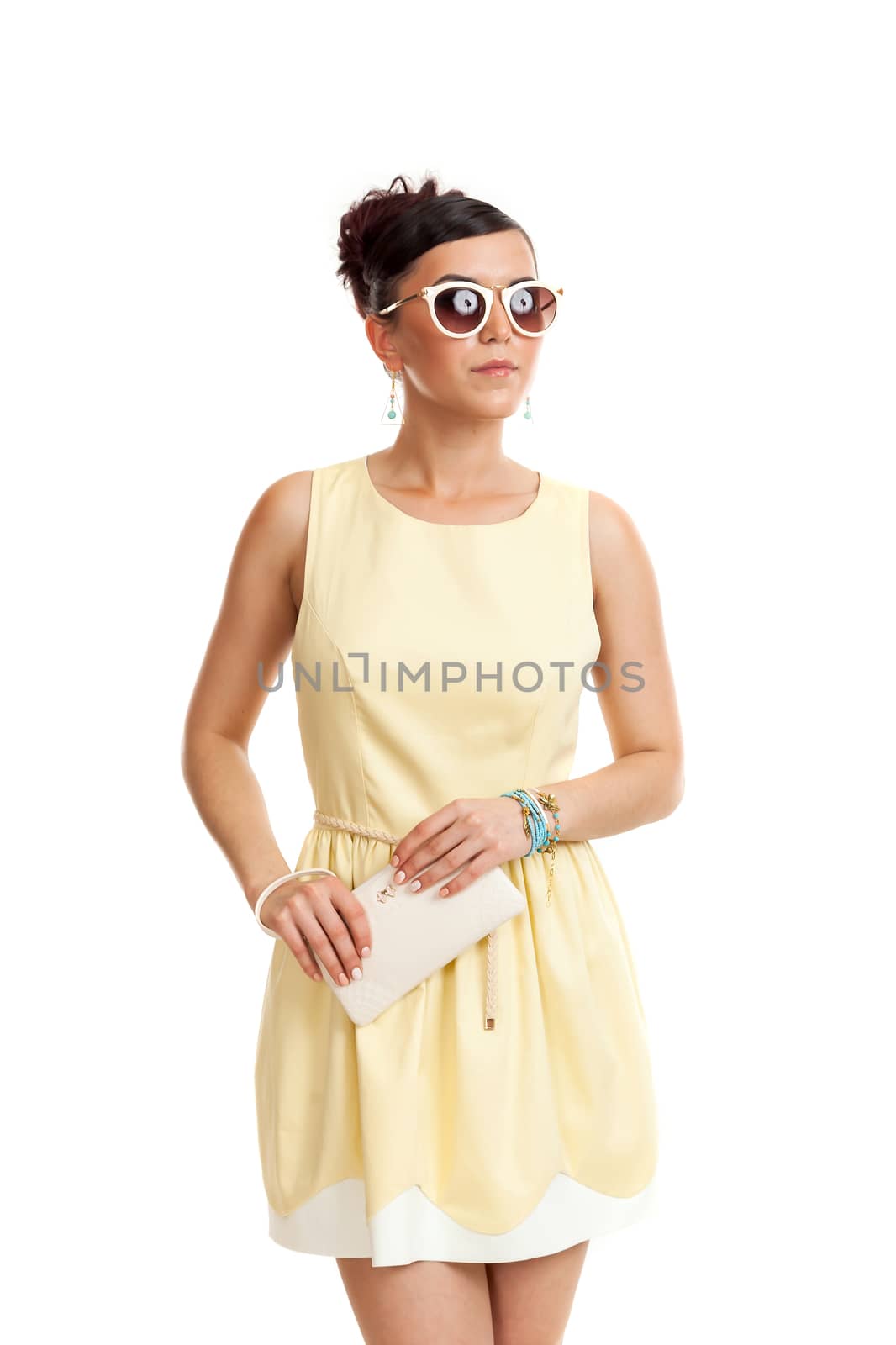 the young woman in sunglasses and in a light dress on a white background