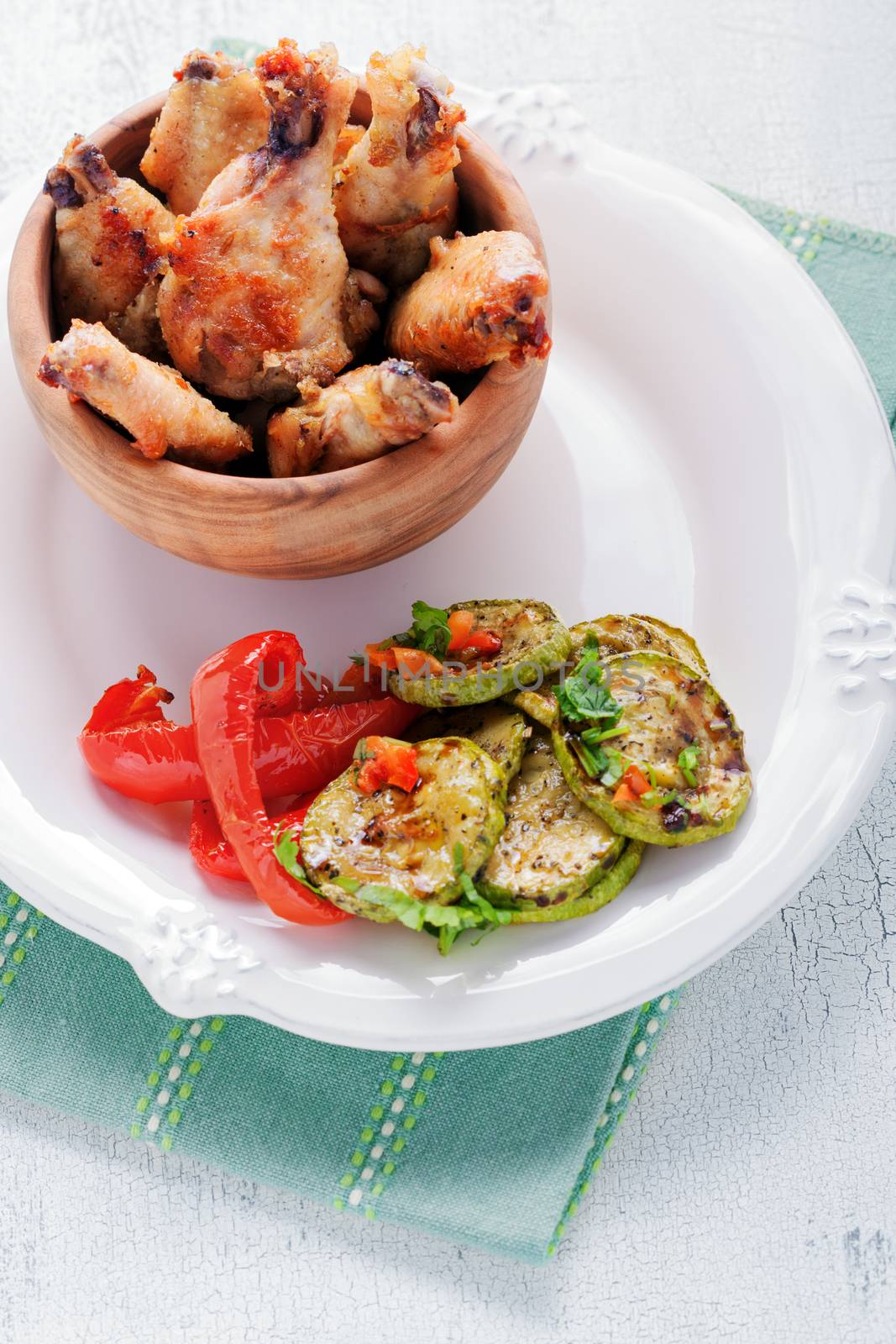 Fried chicken wings and zucchini, pepper on a plate