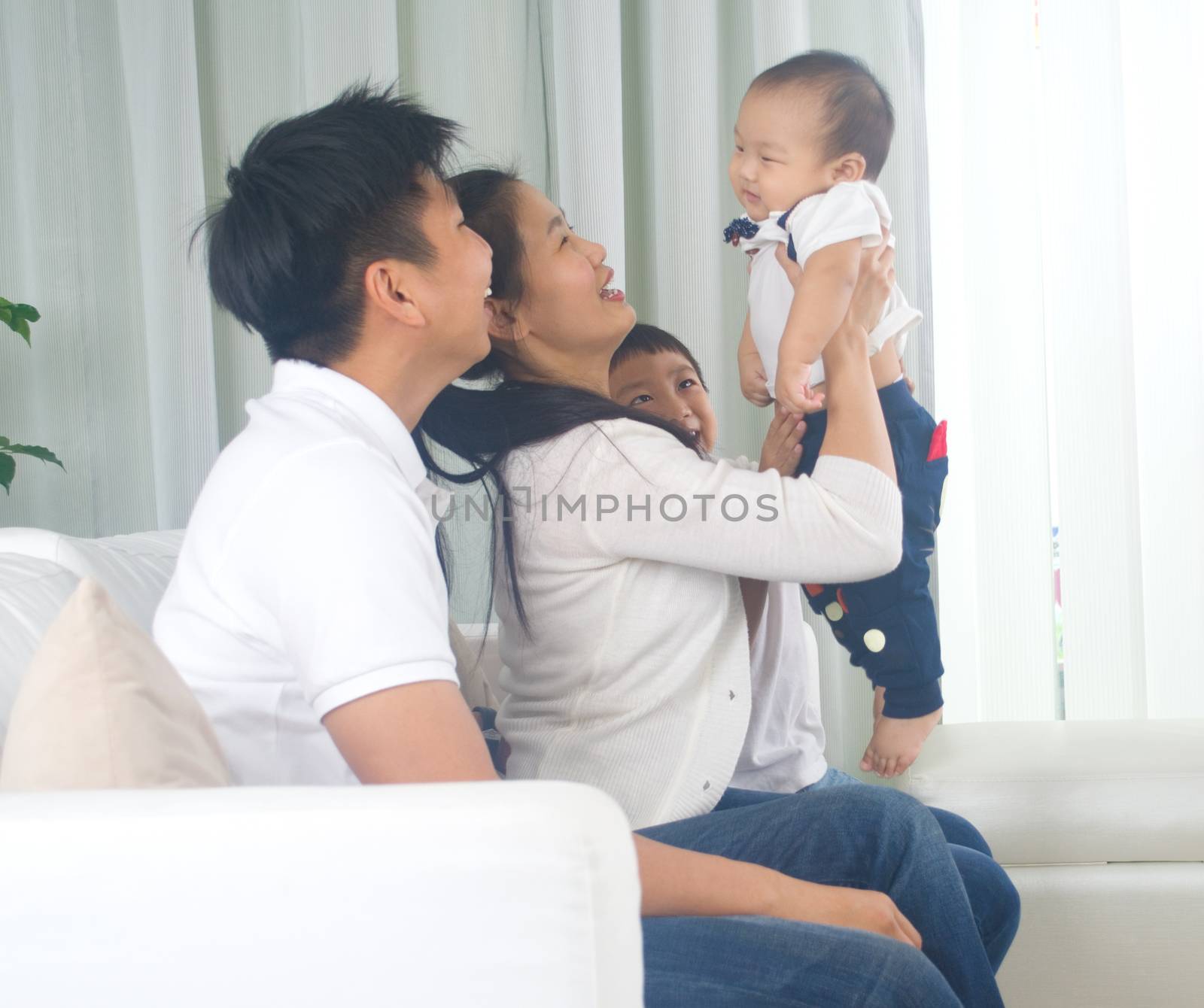 Asian family playing with baby
