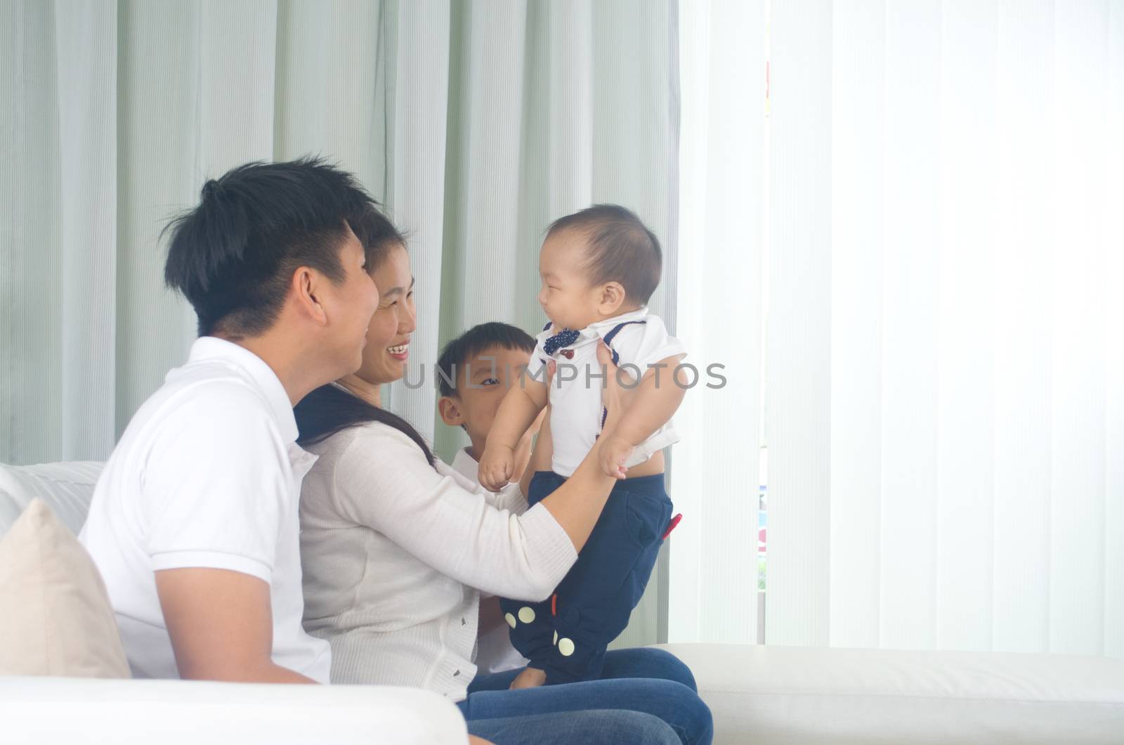 Asian family playing with baby