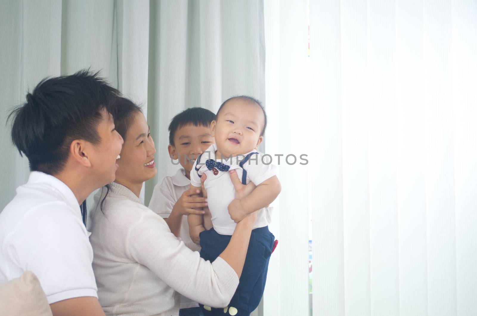 Asian family playing with baby