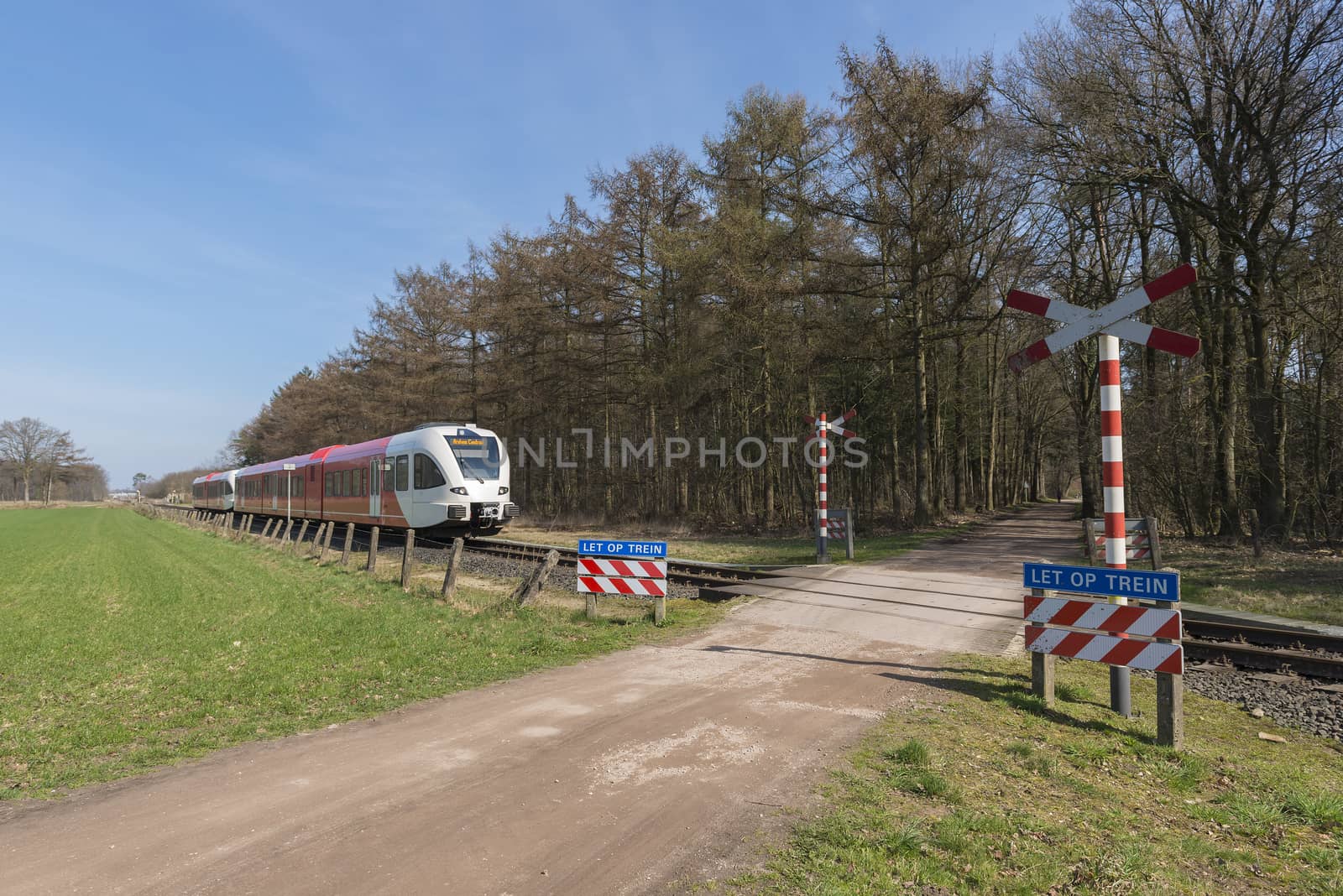 Unguarded, light rail railway crossing without barriers and warning lights in the East of the Netherlands
