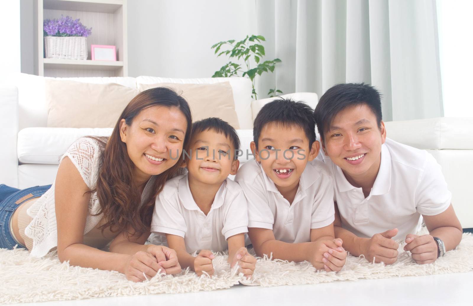 Asian family lying on the floor and smiling