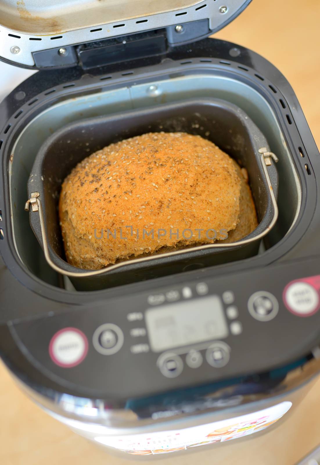 Bread machine with pan and fresh bread at home