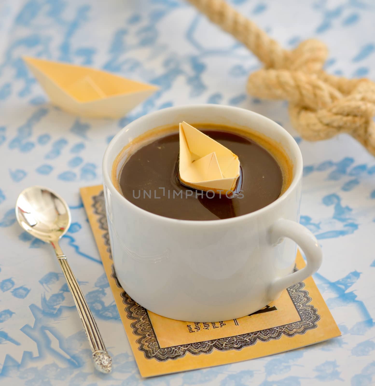coffee cup and paper boat on map