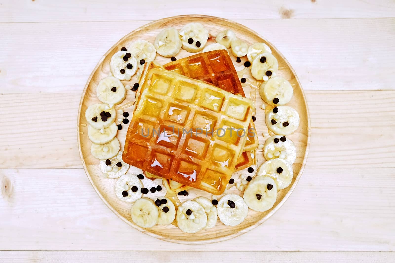 Waffle with Chocolate Chip and Banana on the Table Wooden by aonip