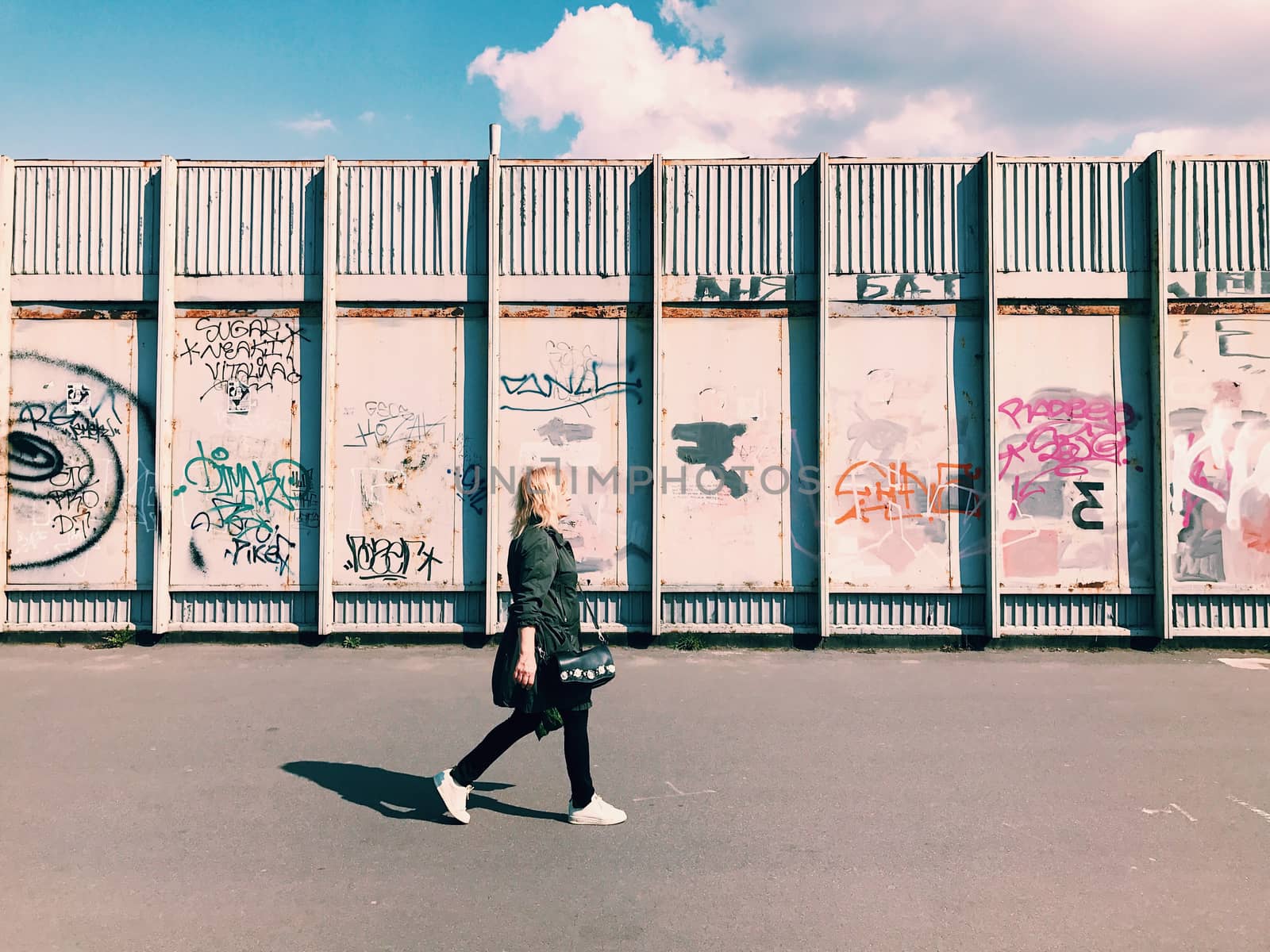 Kiev, Ukraine - April 04, 2017: Pedestrian goes Graffiti wall background. Urban street