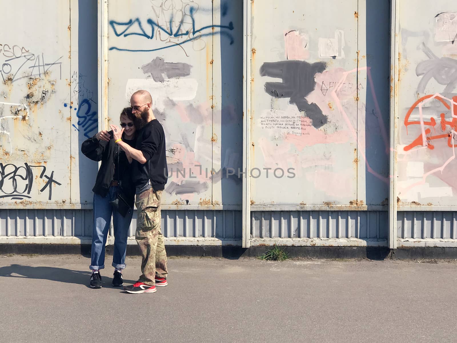 Kiev, Ukraine - April 04, 2017: Happy couple taking a picture on a wall background with graffiti