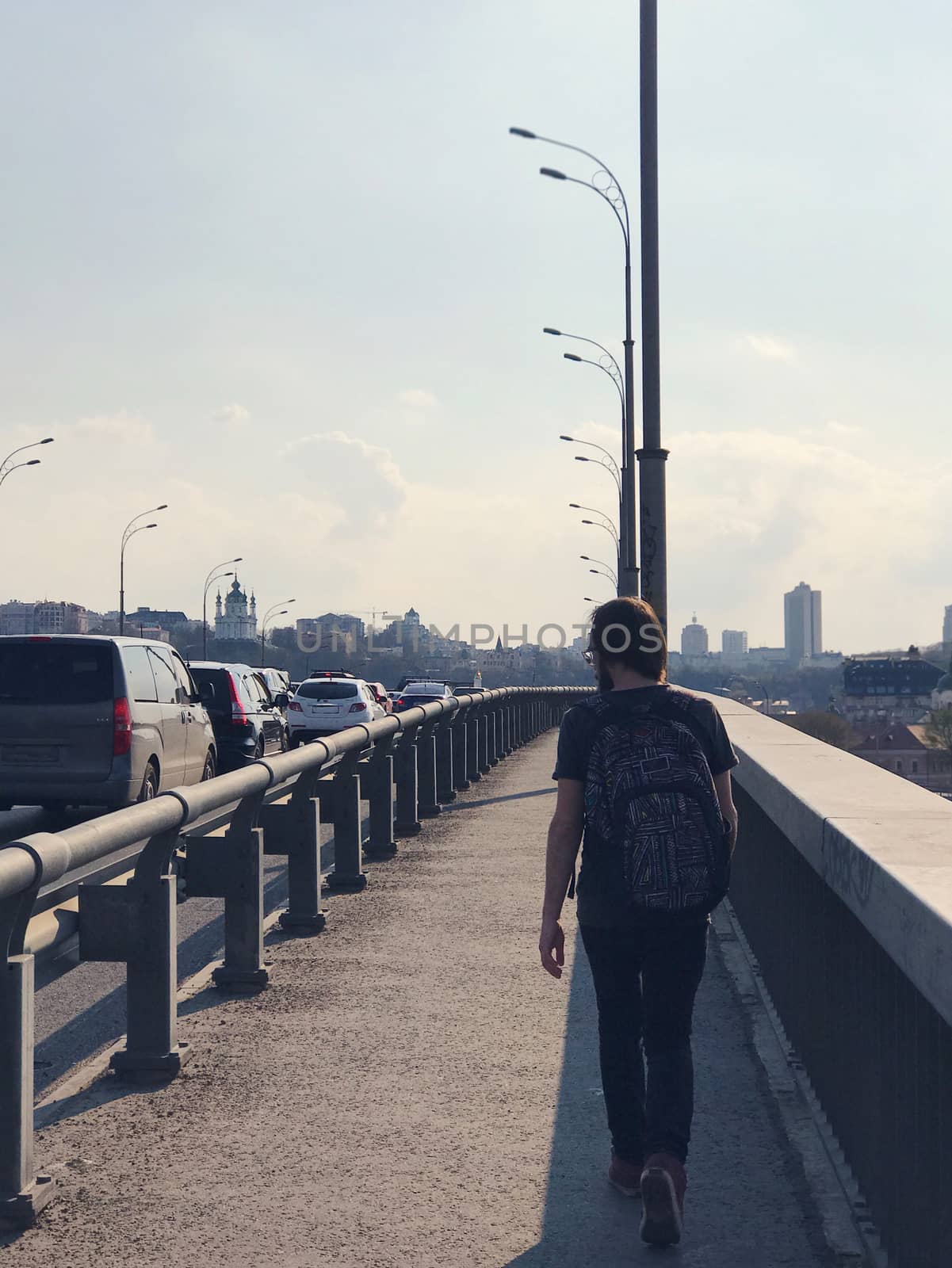 One man walks on a bridge in a big city