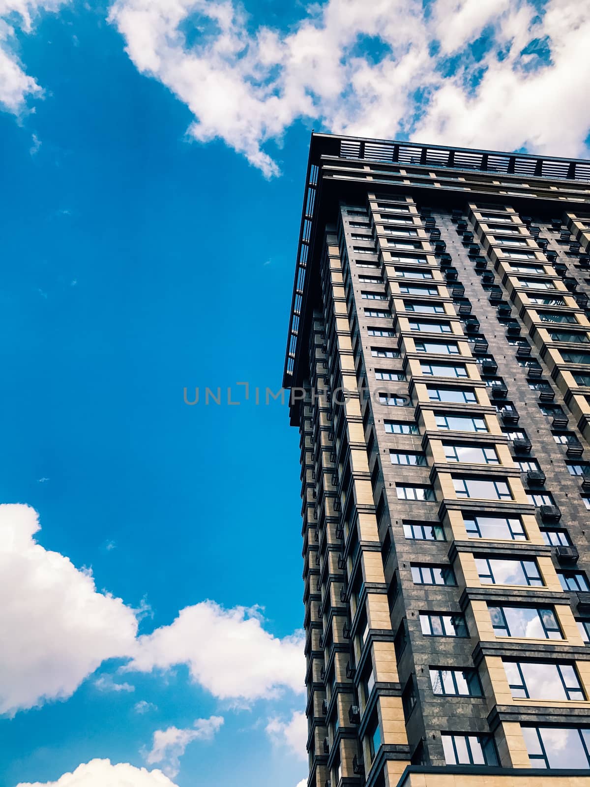 Top part of high-rise business building on blue sky 