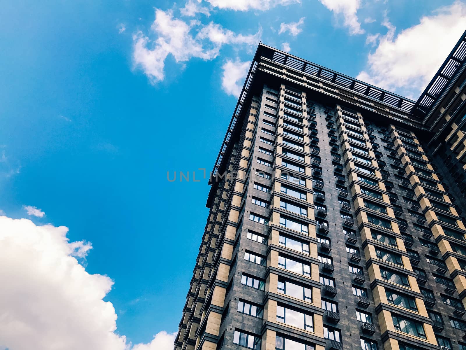 Top part of high-rise business building on blue sky 