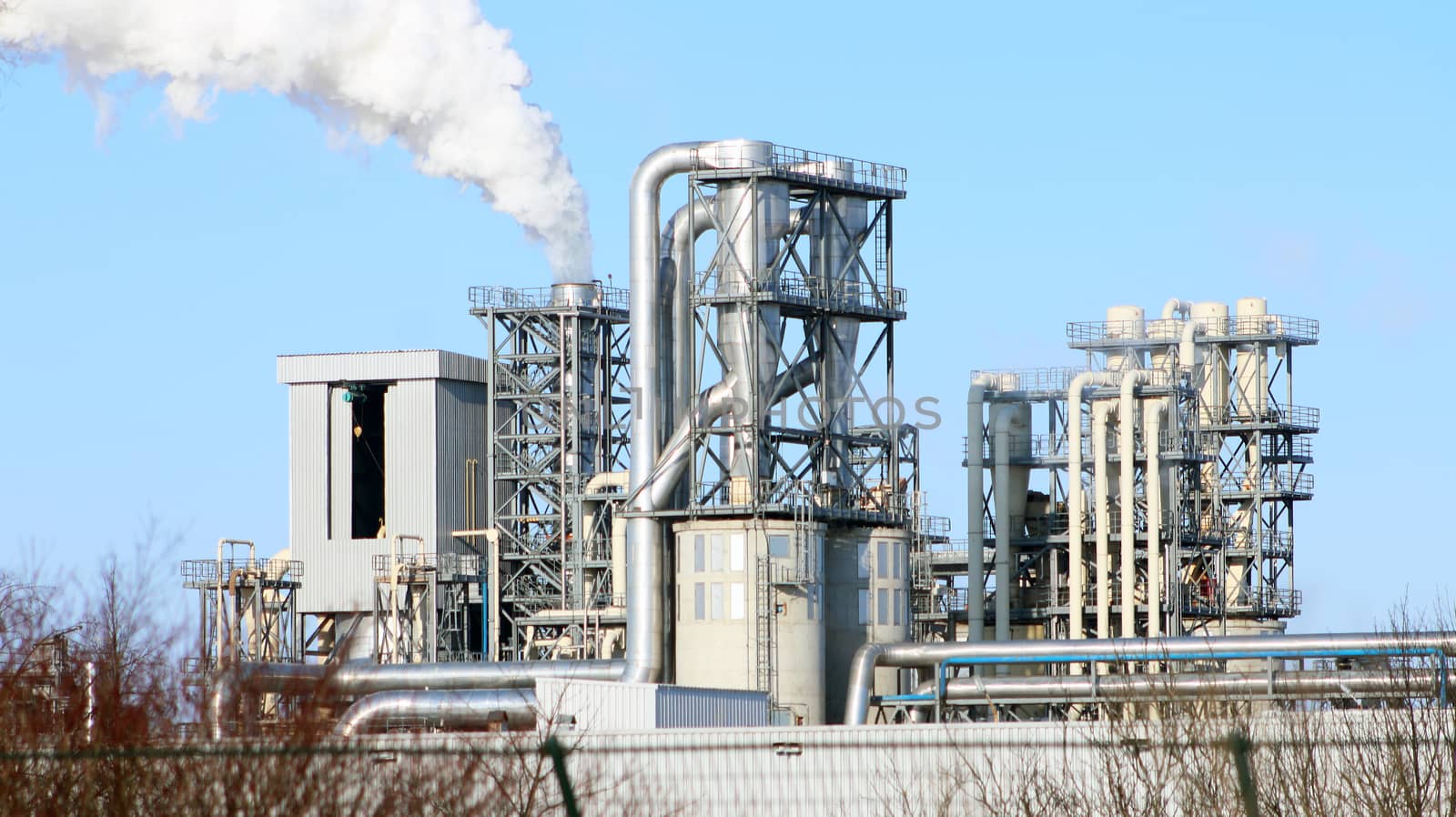 Factory smokes a tree. White smoke from the chimney on blue sky background. Ecology industry environment factory pollution