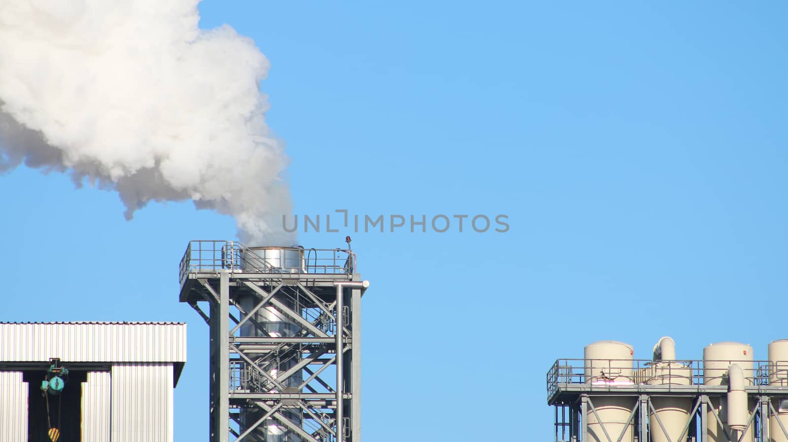 White smoke from the pipe chimney on blue sky background. Industry factory environment ecology pollution