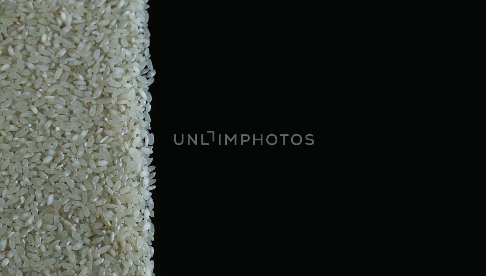 Rice spill left on black background. Agriculture food raw seed. Closeup macro photo
