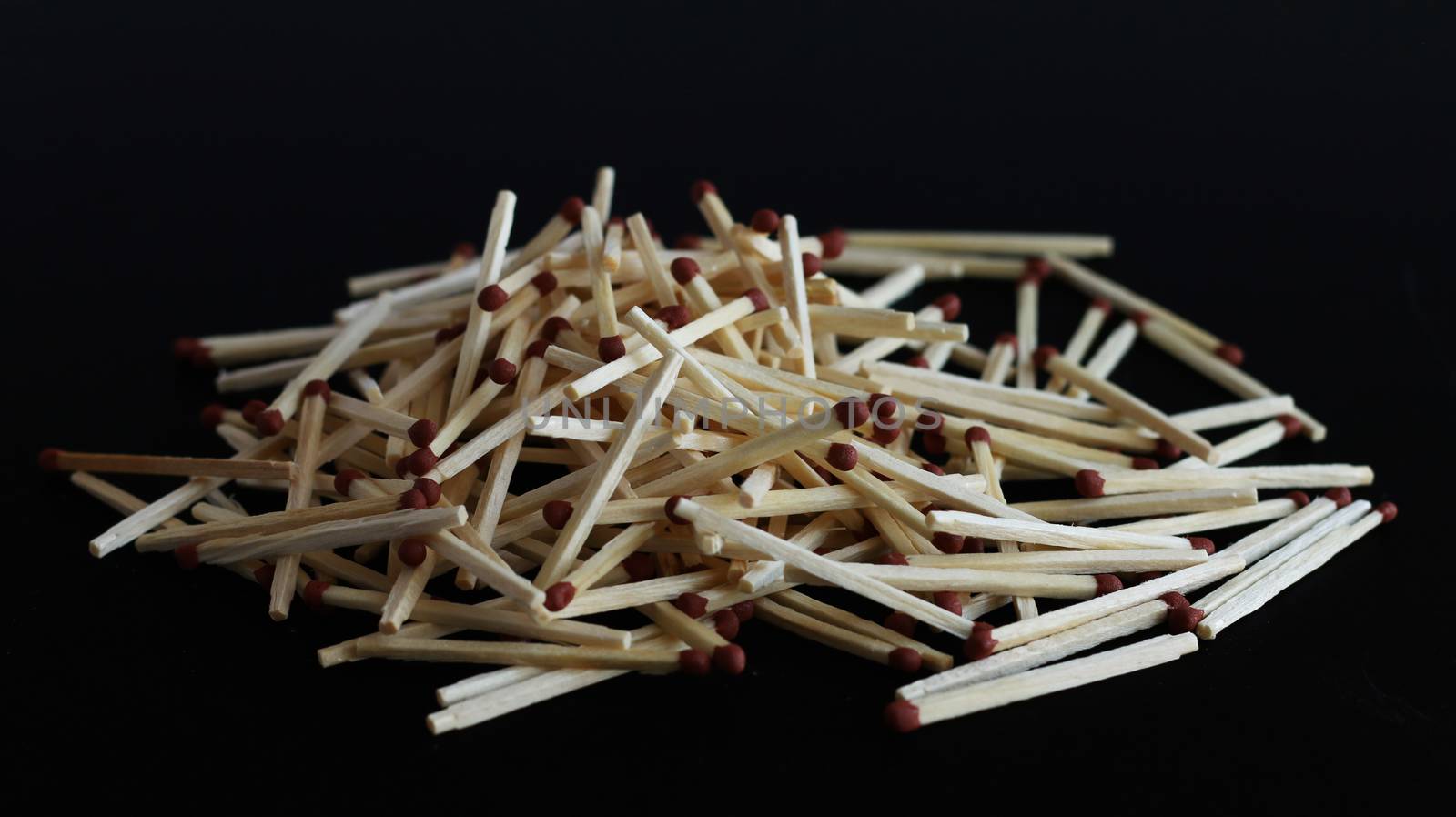 Spill matches on black background. Matchstick pile heap