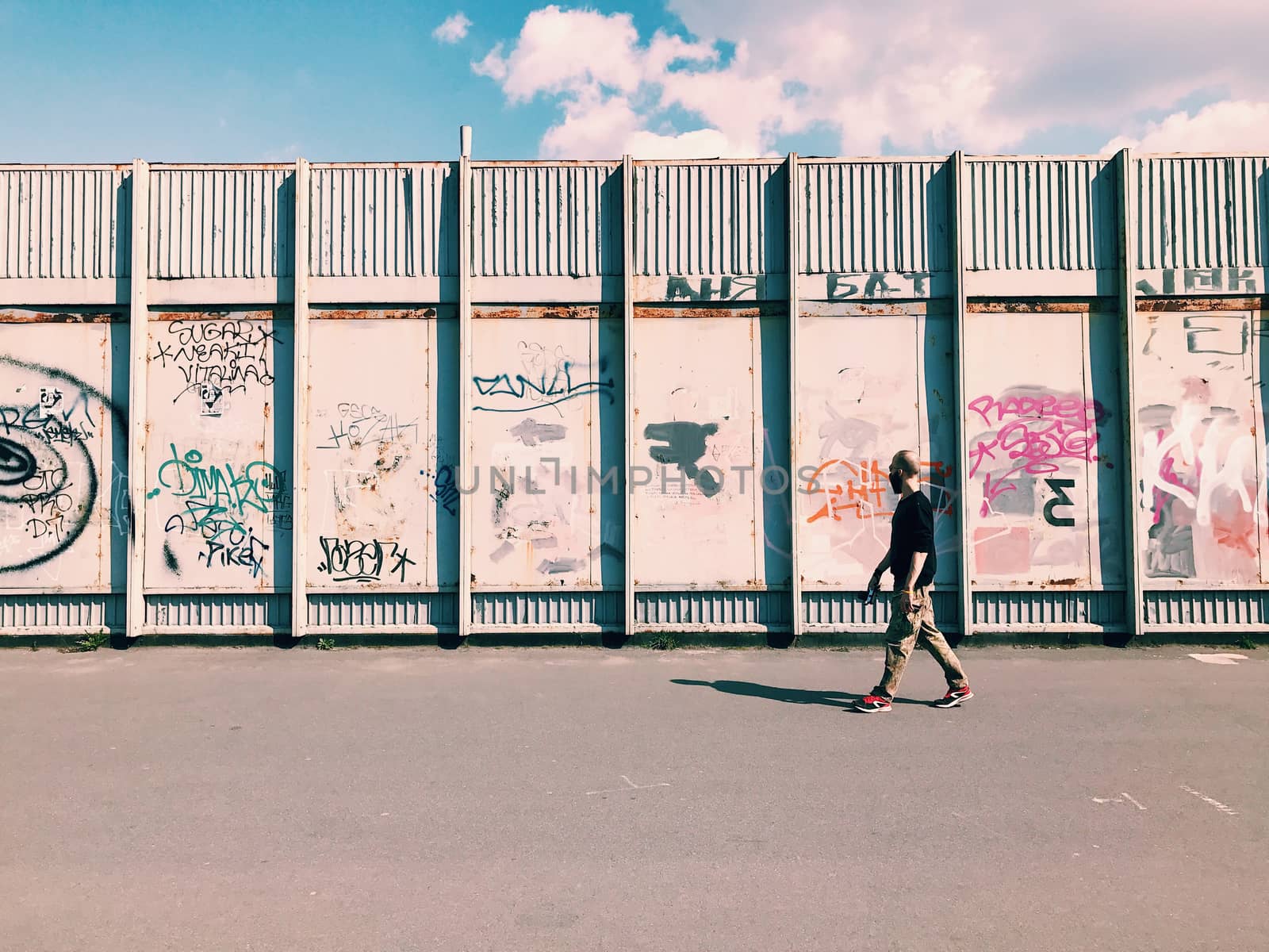 Man pedestrian goes Graffiti wall background. Urban street