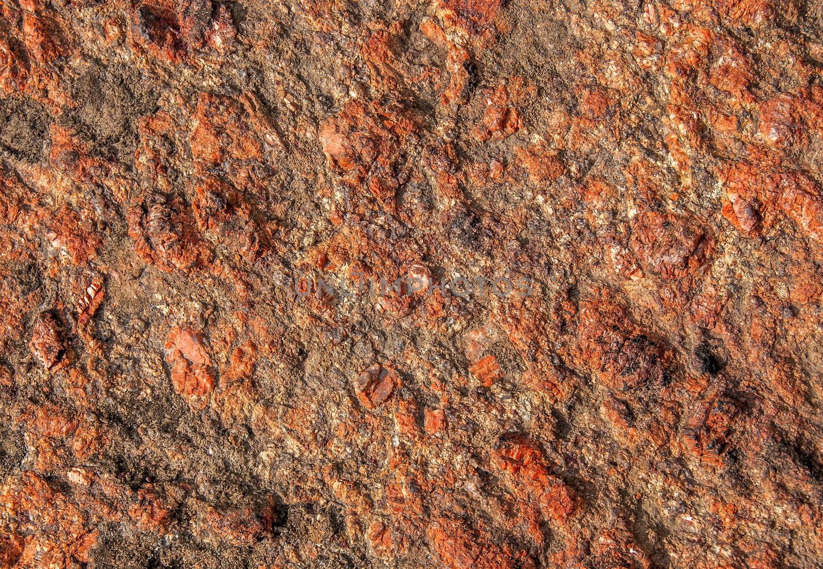 Abstract background of red granite with a rough surface