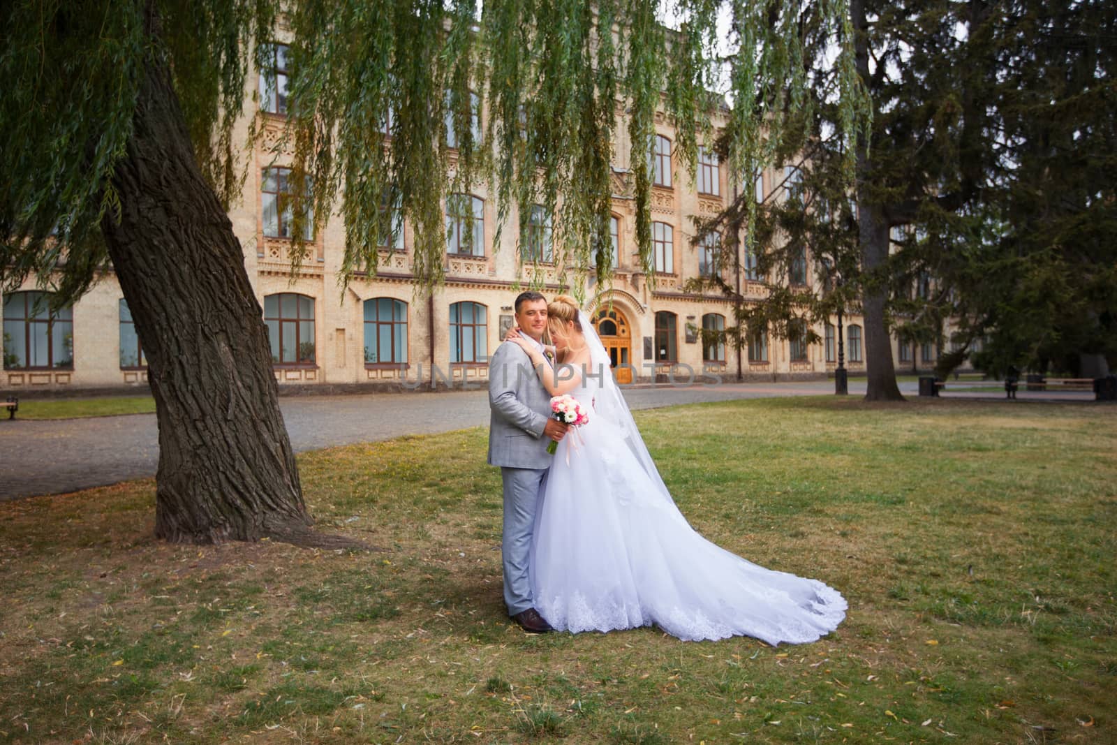 Newlyweds on a walk in the summer day wedding