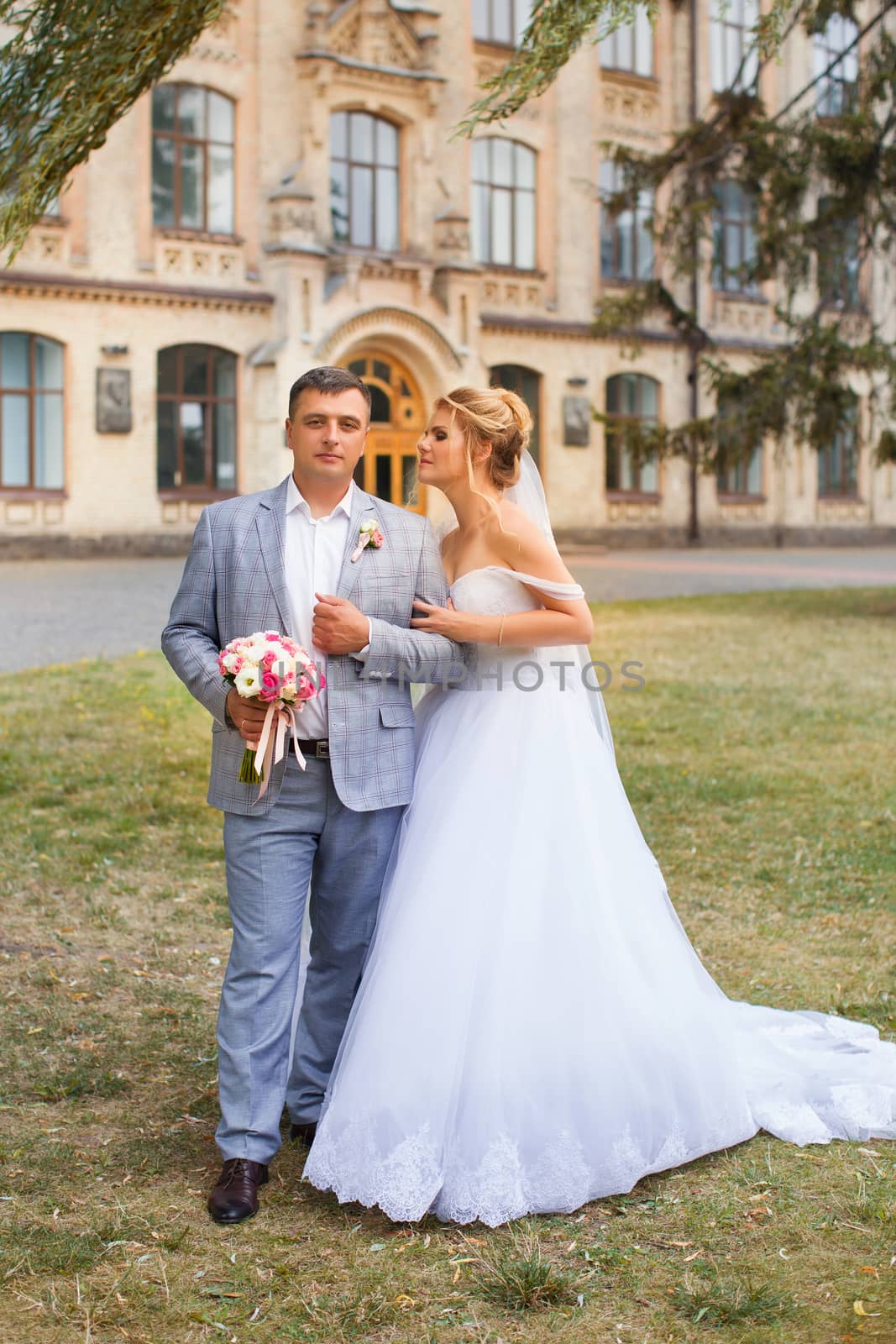 Newlyweds on a walk in the summer day wedding