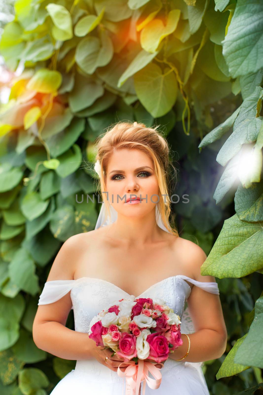 Stylish bride in a white wedding dress in summer day