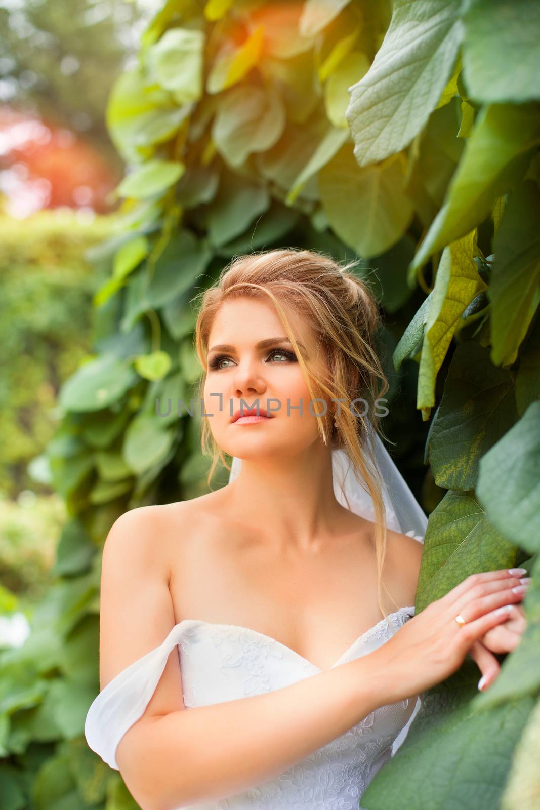 Stylish bride in a white wedding dress in summer day