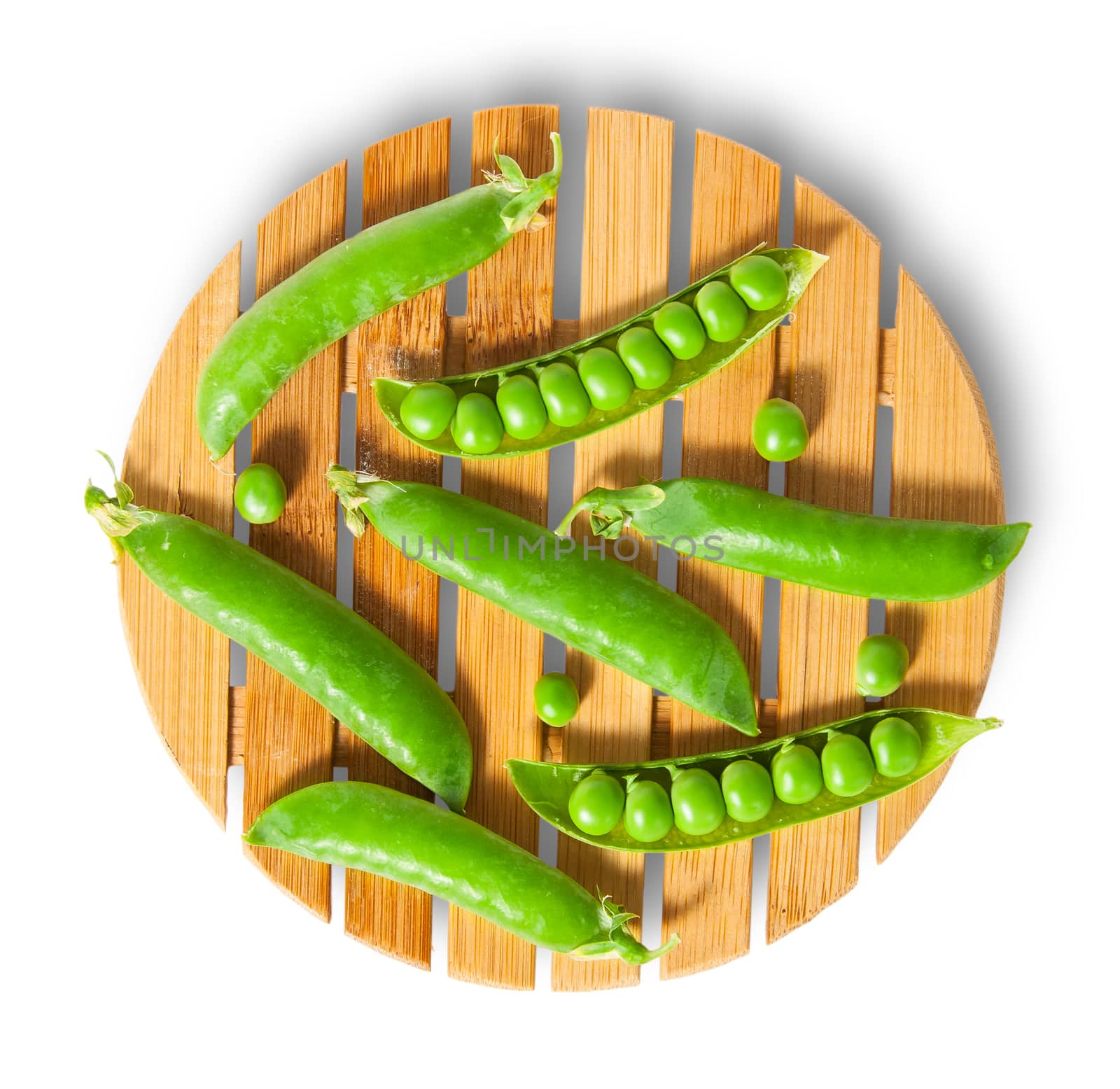 Pods of peas on bamboo board top view isolated on white background