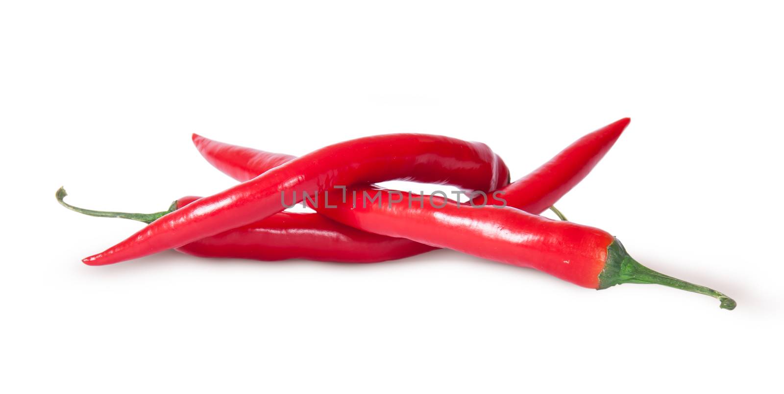 Pile of three red chili peppers isolated on white background