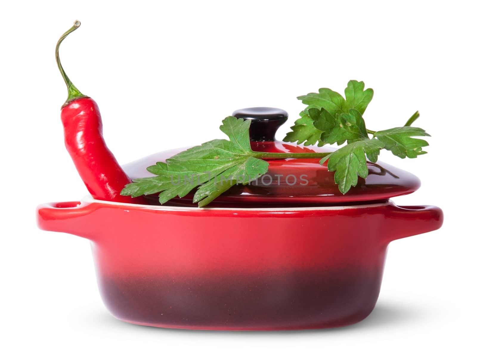 Red chili pepper in saucepan with lid and parsley on top isolated on white background