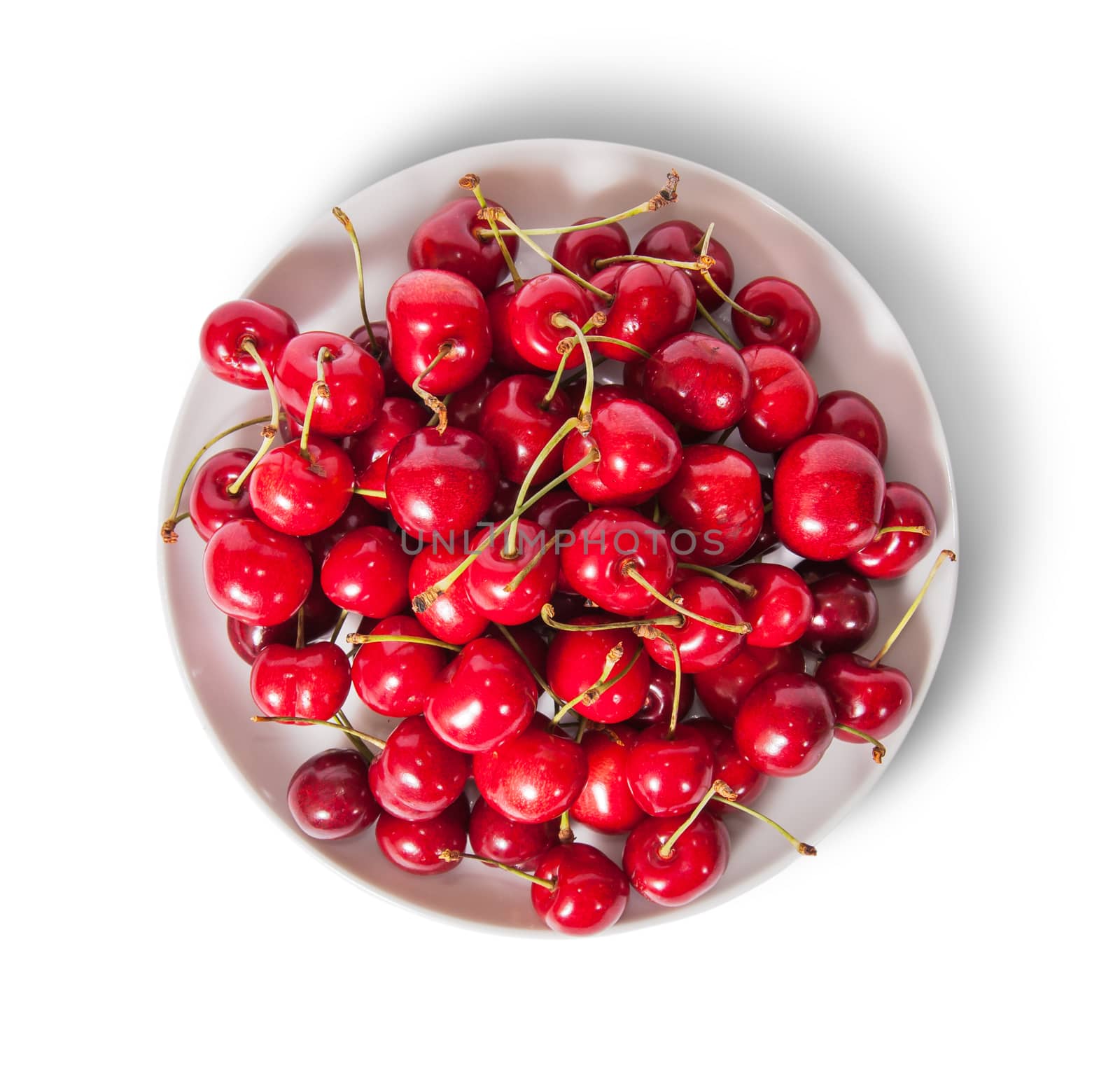 Red sweet cherries in white plate top view isolated on white background