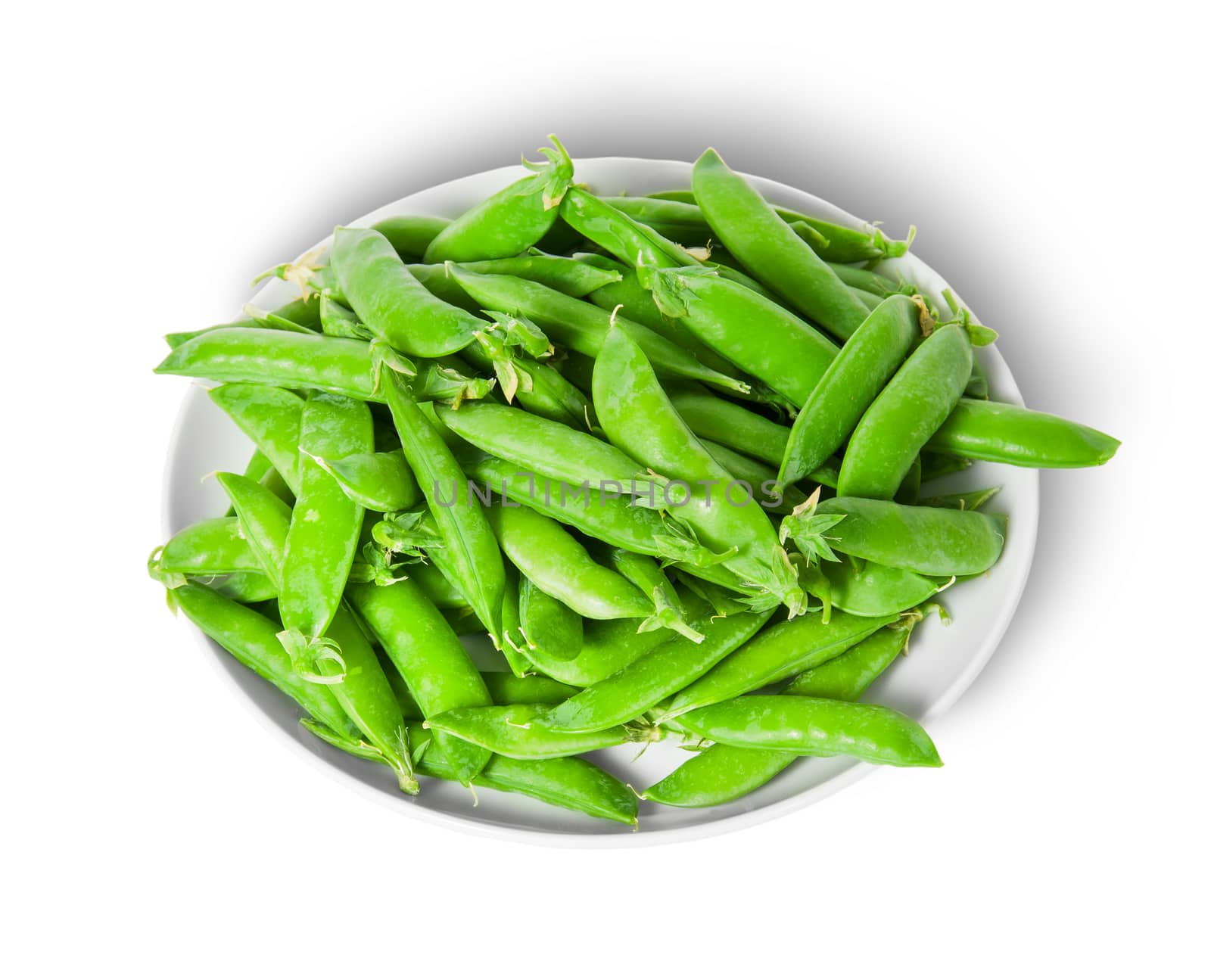 Small pile of green peas in pods on white plate isolated on white background