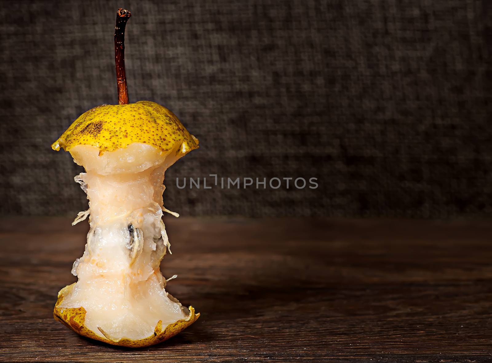 Stub of pear on wooden table by Cipariss