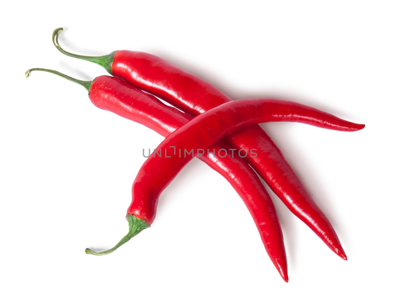 Three juicy red ripe sharp intersecting chili peppers isolated on white background