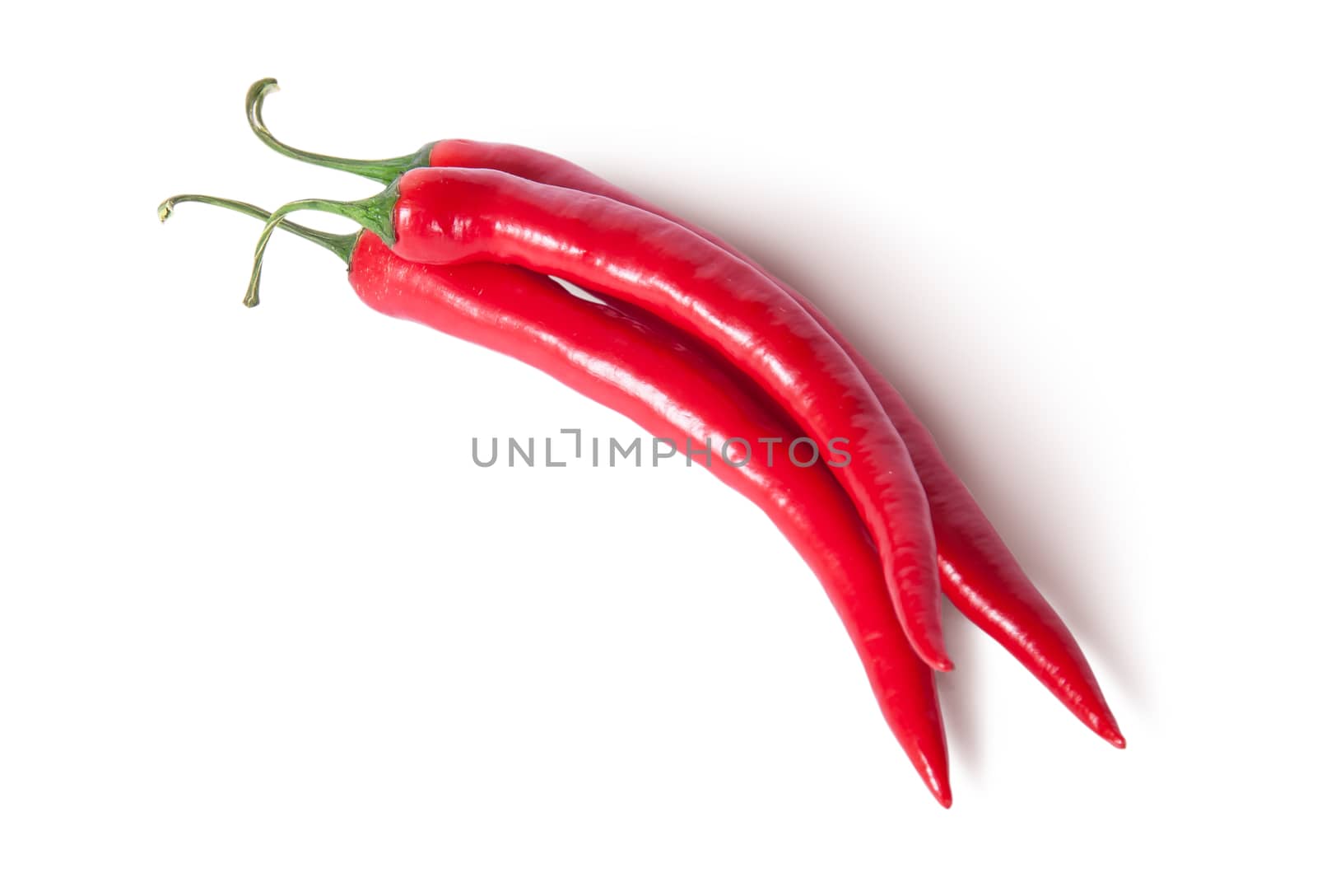 Three red ripe juicy hot chili peppers top view isolated on white background