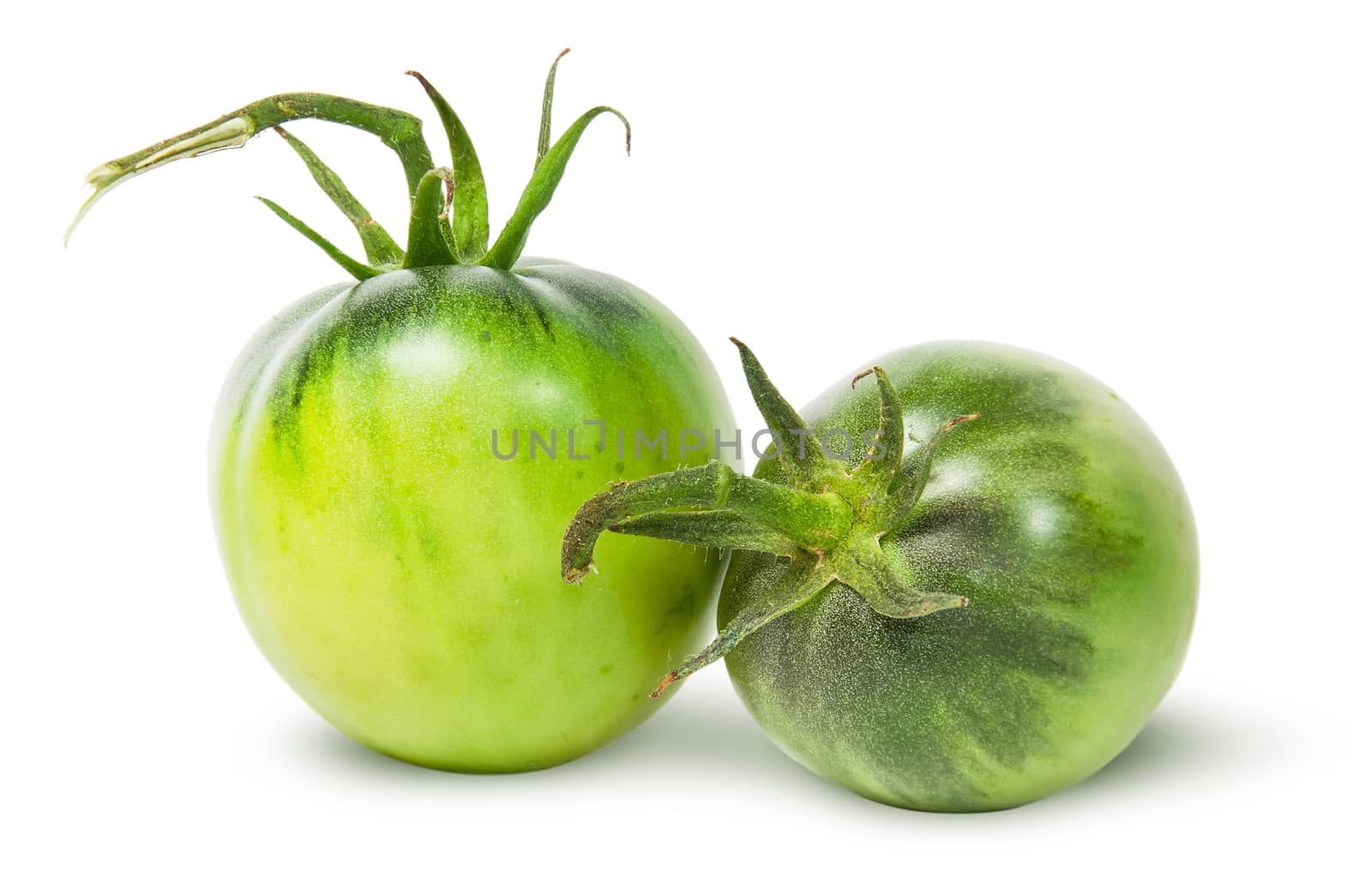 Two green tomatoes near isolated on white background