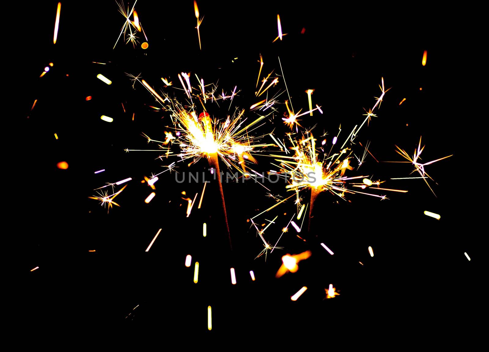 Two bright festive New Year Christmas sparklers on black background