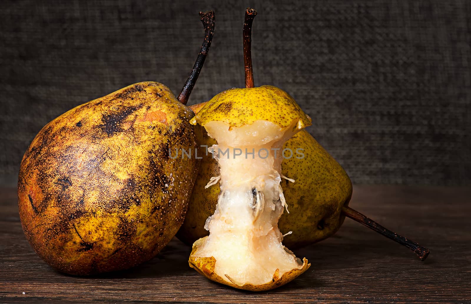 Two pears and stub standing on wooden table background sacking