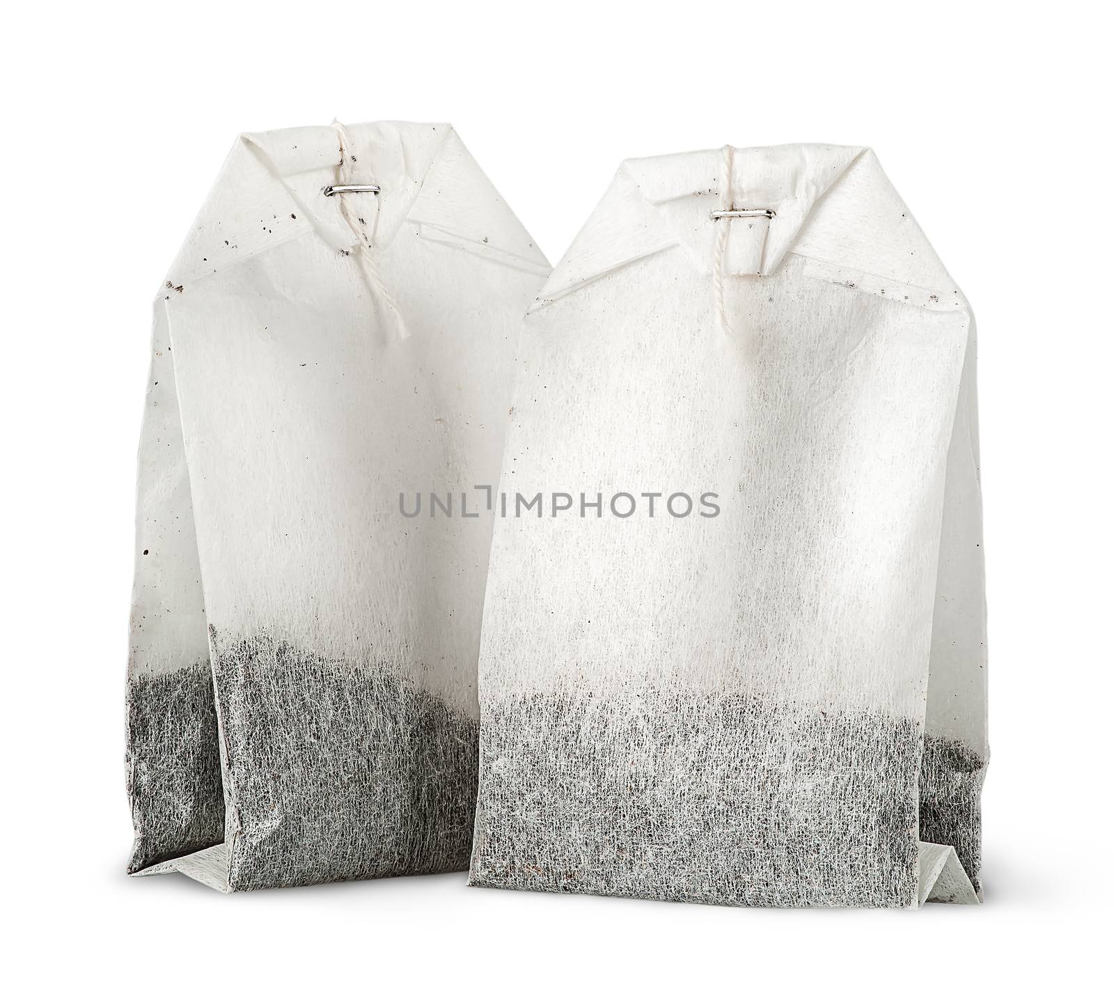 Two tea bags with thread vertically isolated on white background