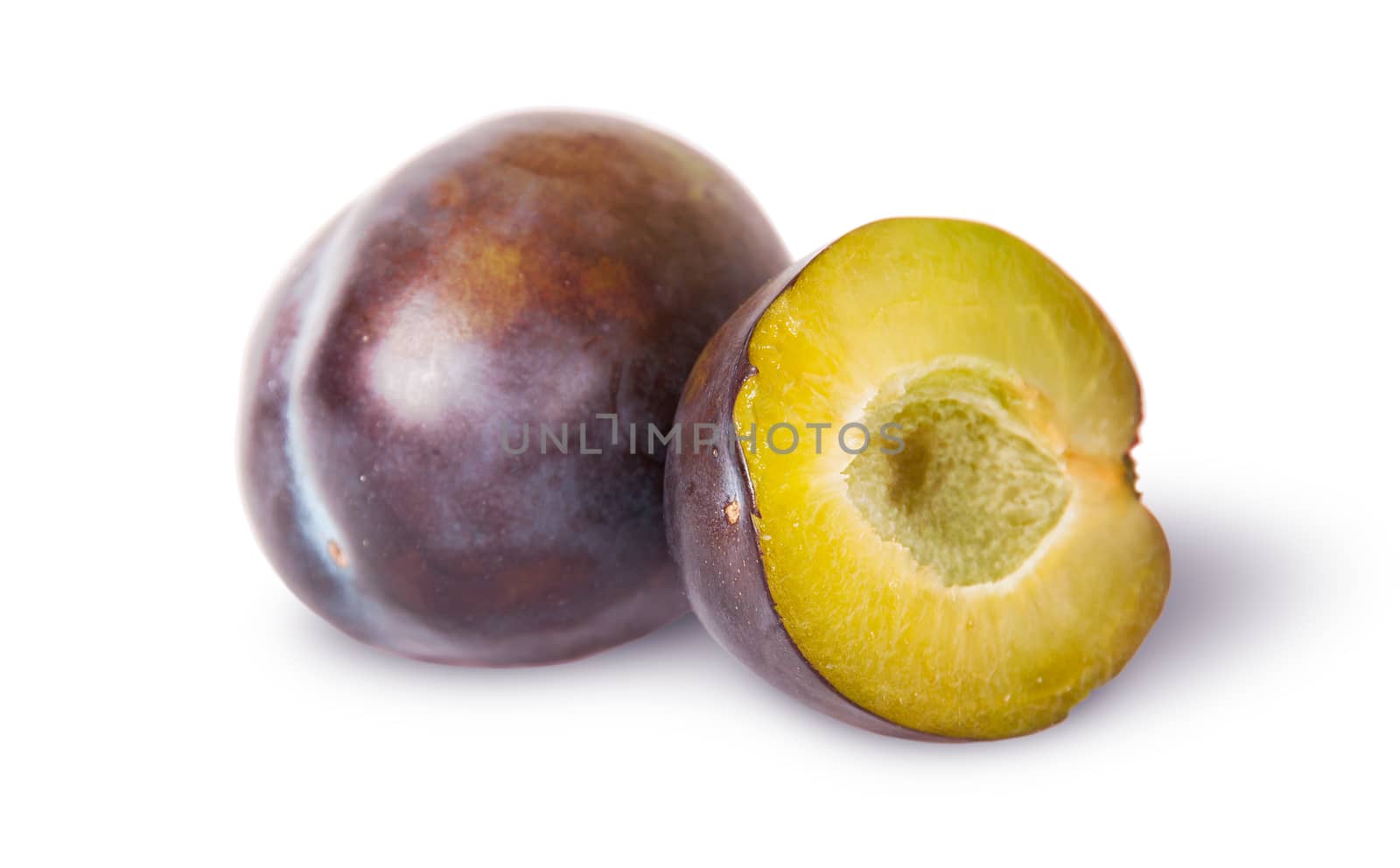 Whole and half of violet plums near isolated on white background