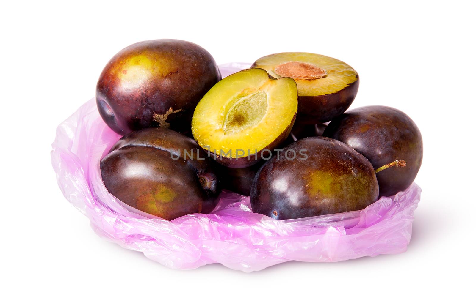Whole and half violet plums in plastic bag isolated on white background