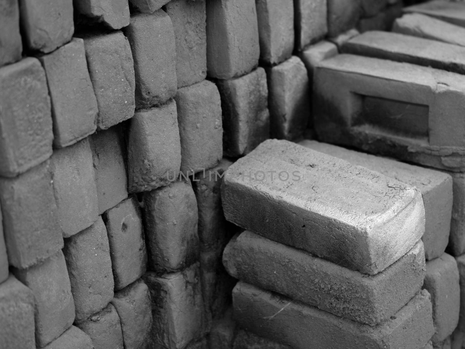 BLACK AND WHITE PHOTO OF PILE OF RED CLAY BRICKS