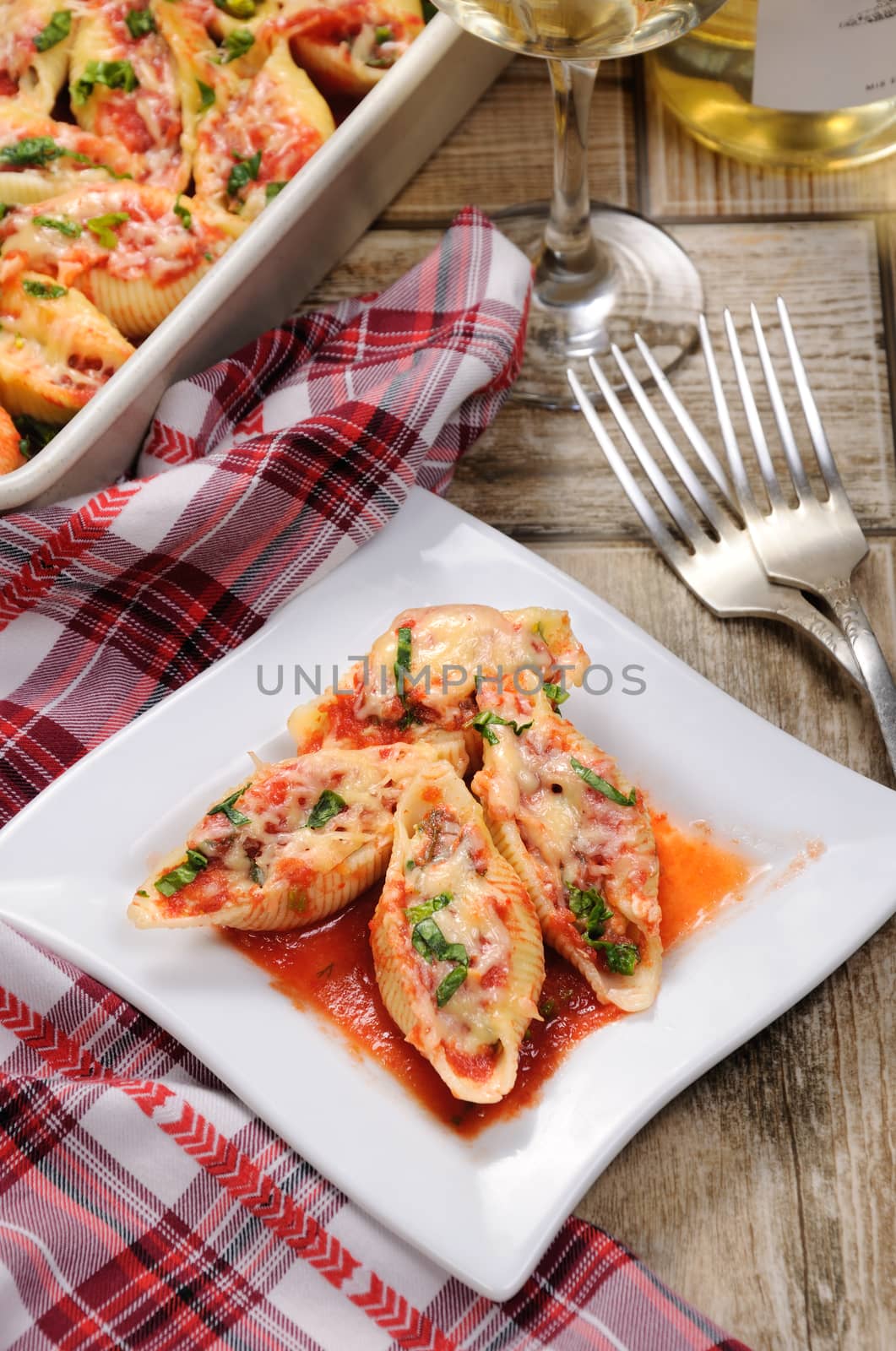 pasta conchiglioni shells stuffed meat mince with spinach and tomato sauce , Parmesan cheese, on a plate.  View from above.