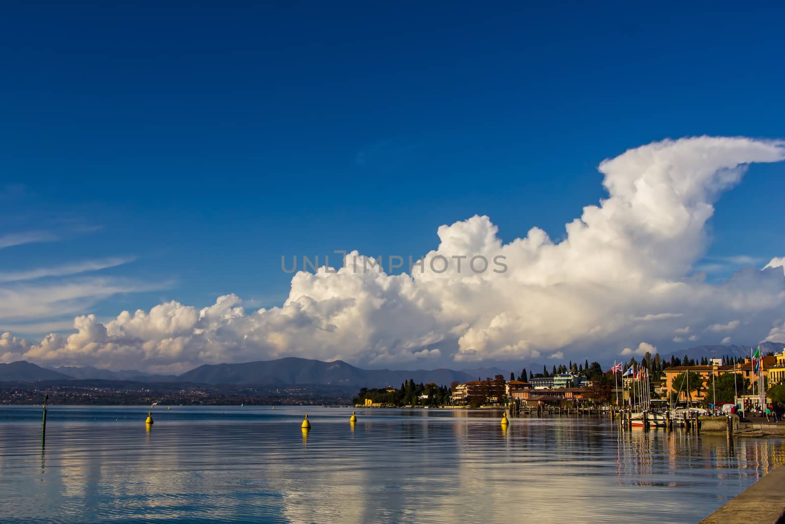 A placid lake reflecting clouds, Lake Garda by huntz