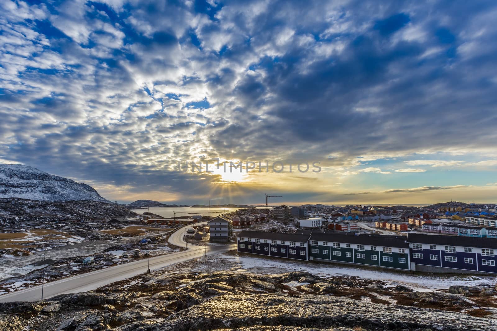 Arctic streets with houses on the rocky hills in sunset city panorama. Nuuk, Greenland